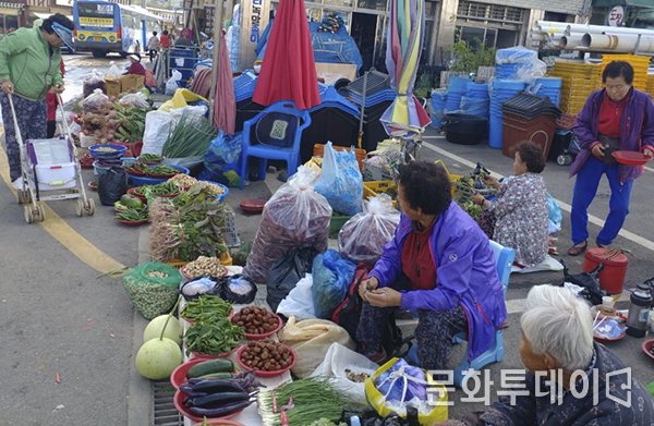 버스에 내려 장터에 찾아오는 손님을 동네 할머니들이 바라보고 있다