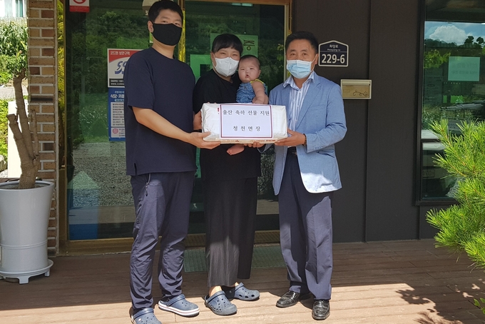 14일 노현호 청천면장이 이하리양 가족에게 선물을 전달하고 있다