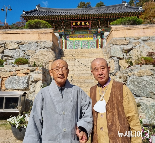 필자 보검스님이 조실 명오스님과 대웅보전 앞에서 손을 맞잡고 미래불교를 창조하자고 다짐하고 있다.