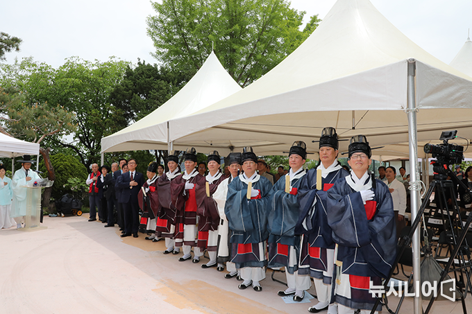 어천절 참례자들이 국민의례를 하고 있다.