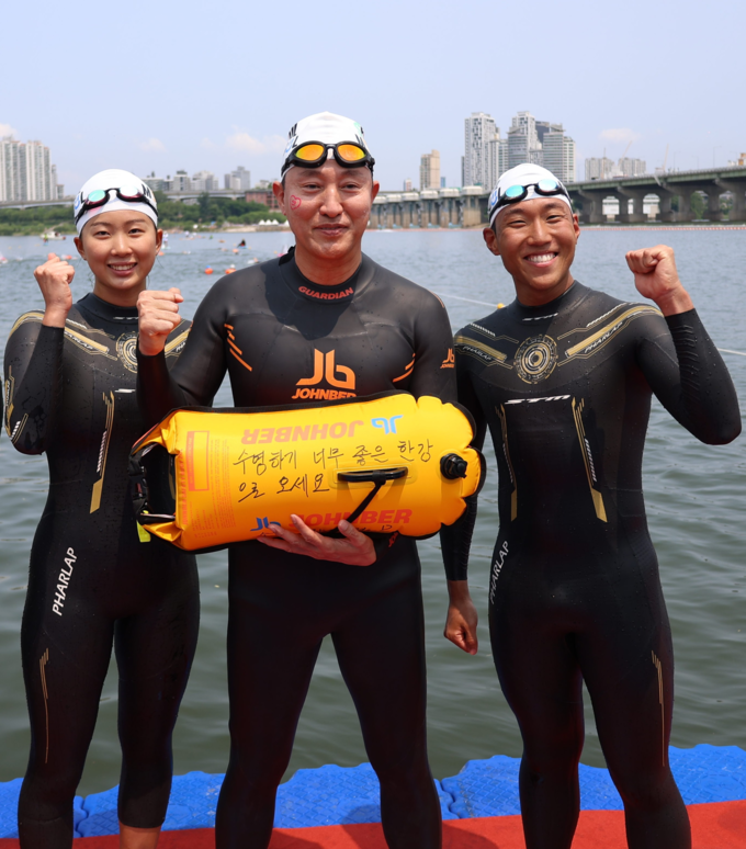 오세훈 서울시장이 30일(금) ‘쉬엄쉬엄 한강 3종 축제’ 1일차 수영종목에 출발 전 ‘수영하기 너무 좋은 한강으로 오세요 수질 환상적’ 안전부이를 들고 도강을 준비하고 있다. (서울특별시)
